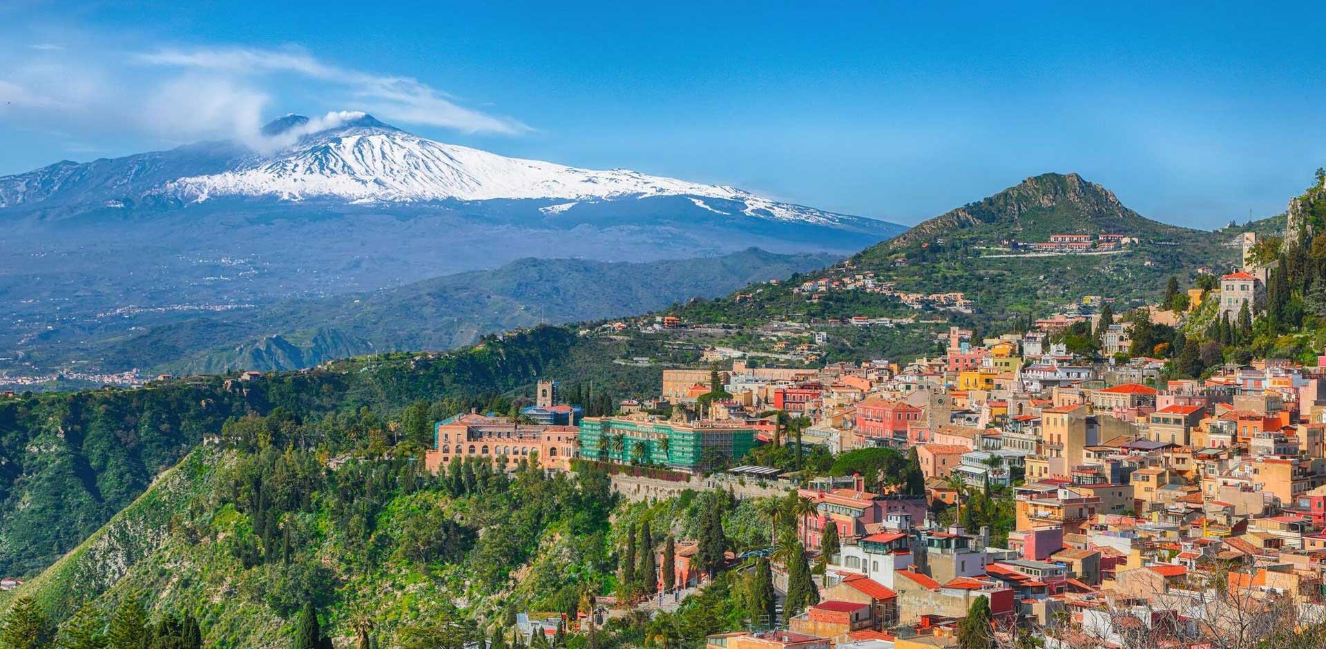 Snow-capped Mount Etna seen from a nearby town.