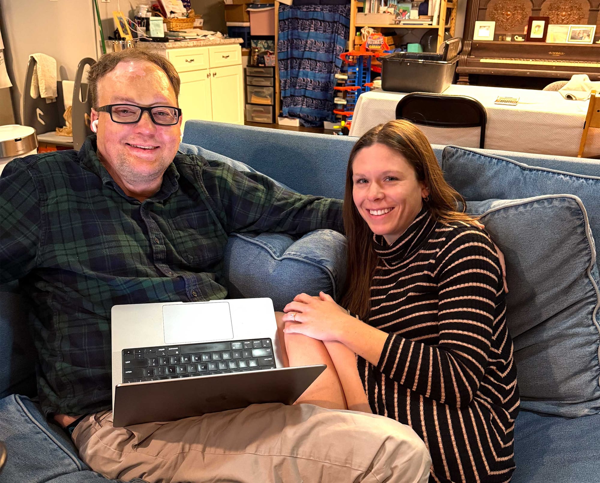 John and Stevie working on the laptop while seated on the sofa.
