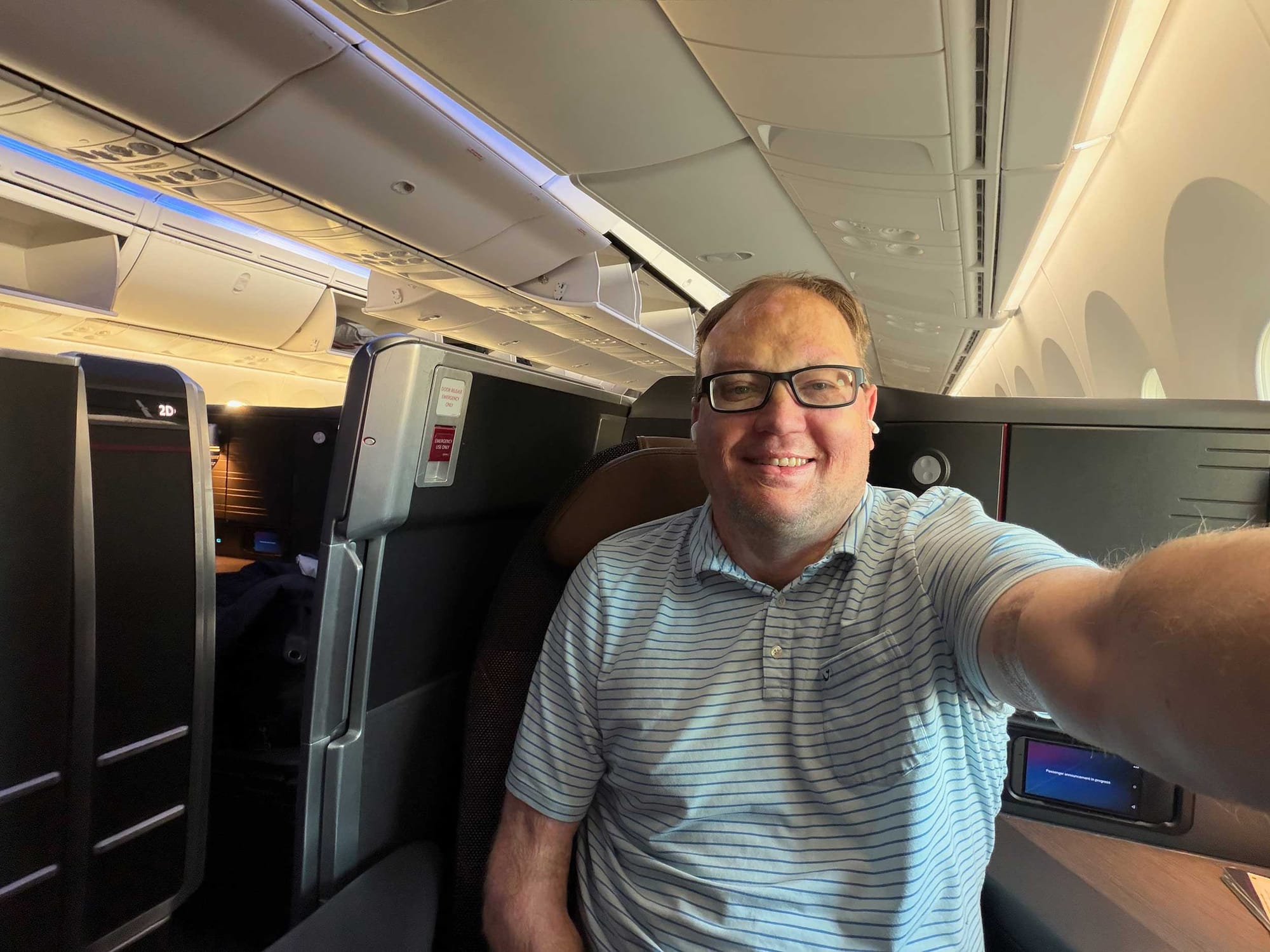 John seated in an enclosed business class suite.