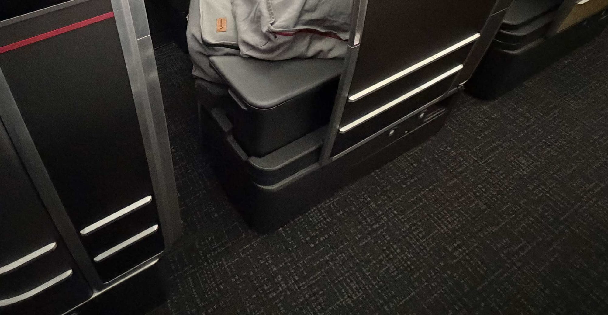 Aisle armrest on American Airlines Flagship Suite business class seat.