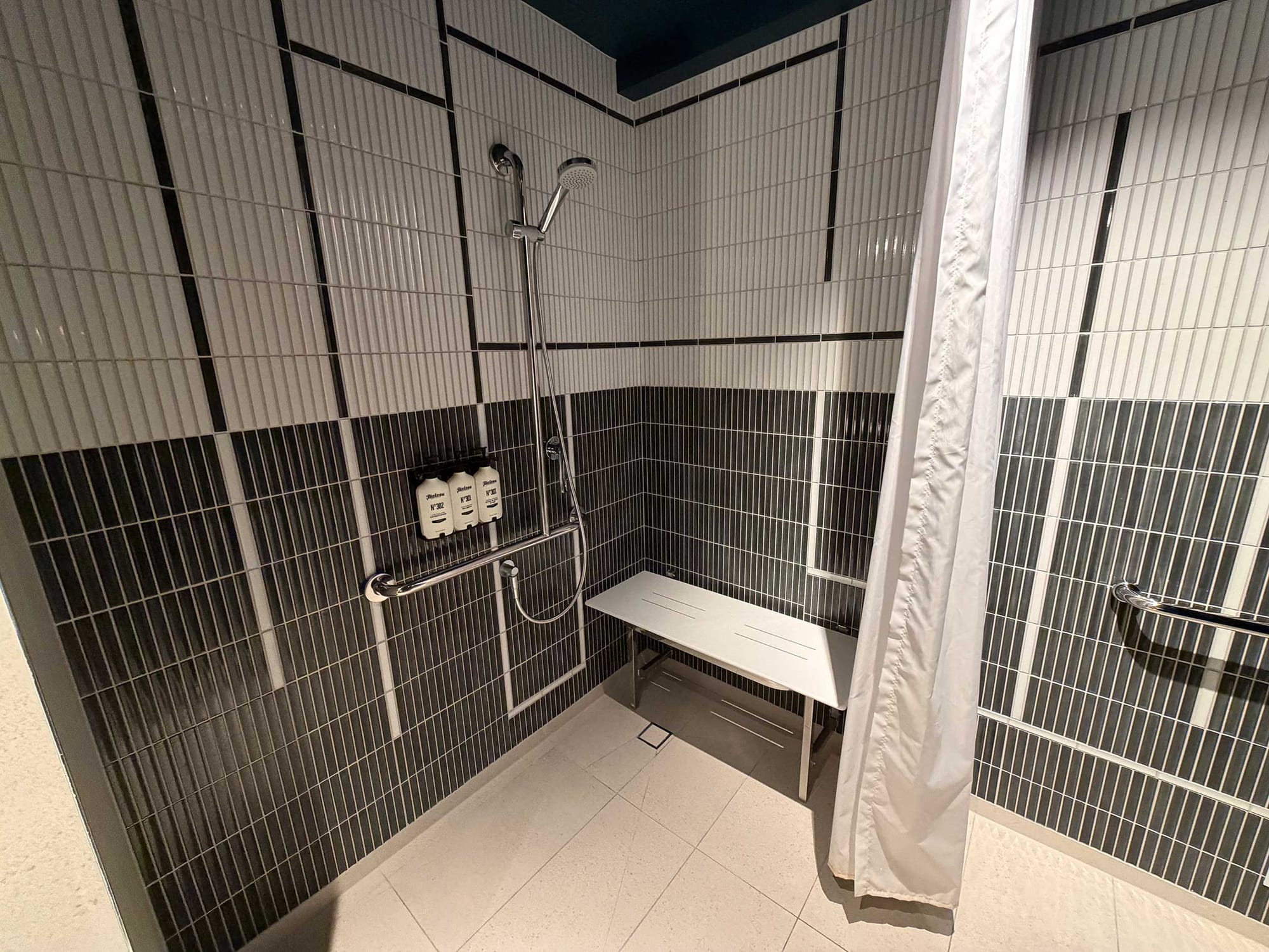 Roll-in shower with grab bars and seat.