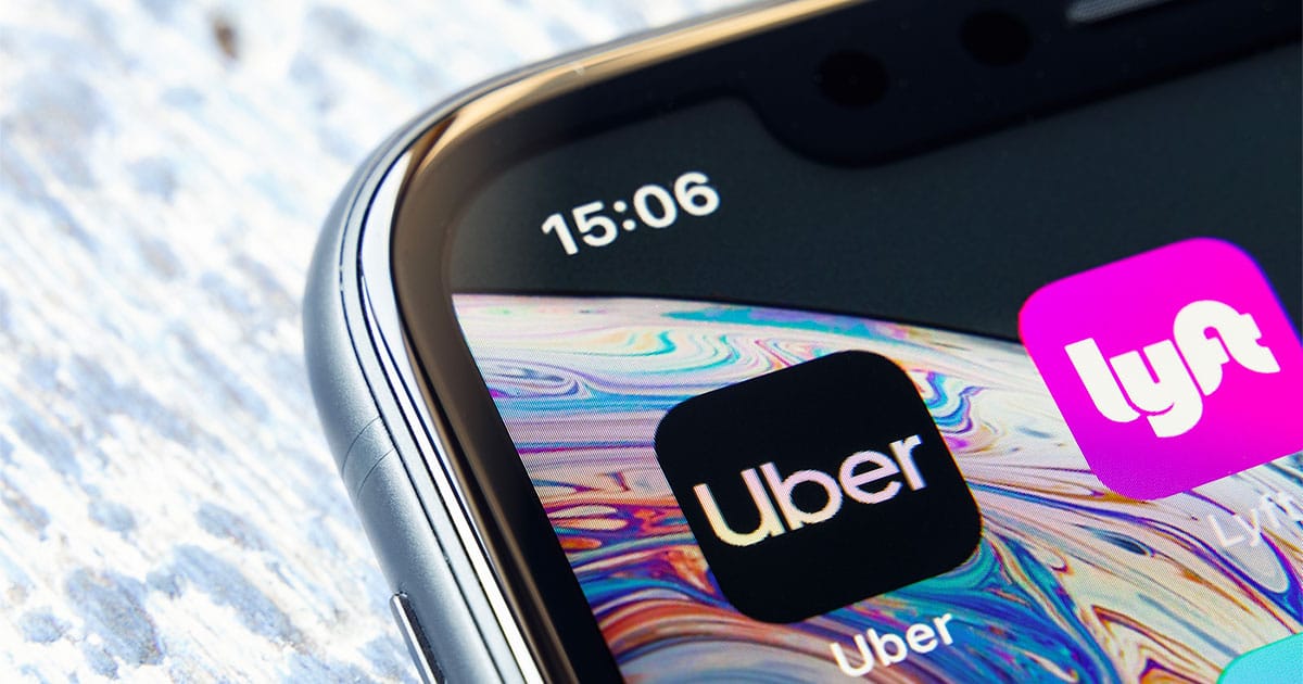 Uber and Lyft apps on iPhone screen.