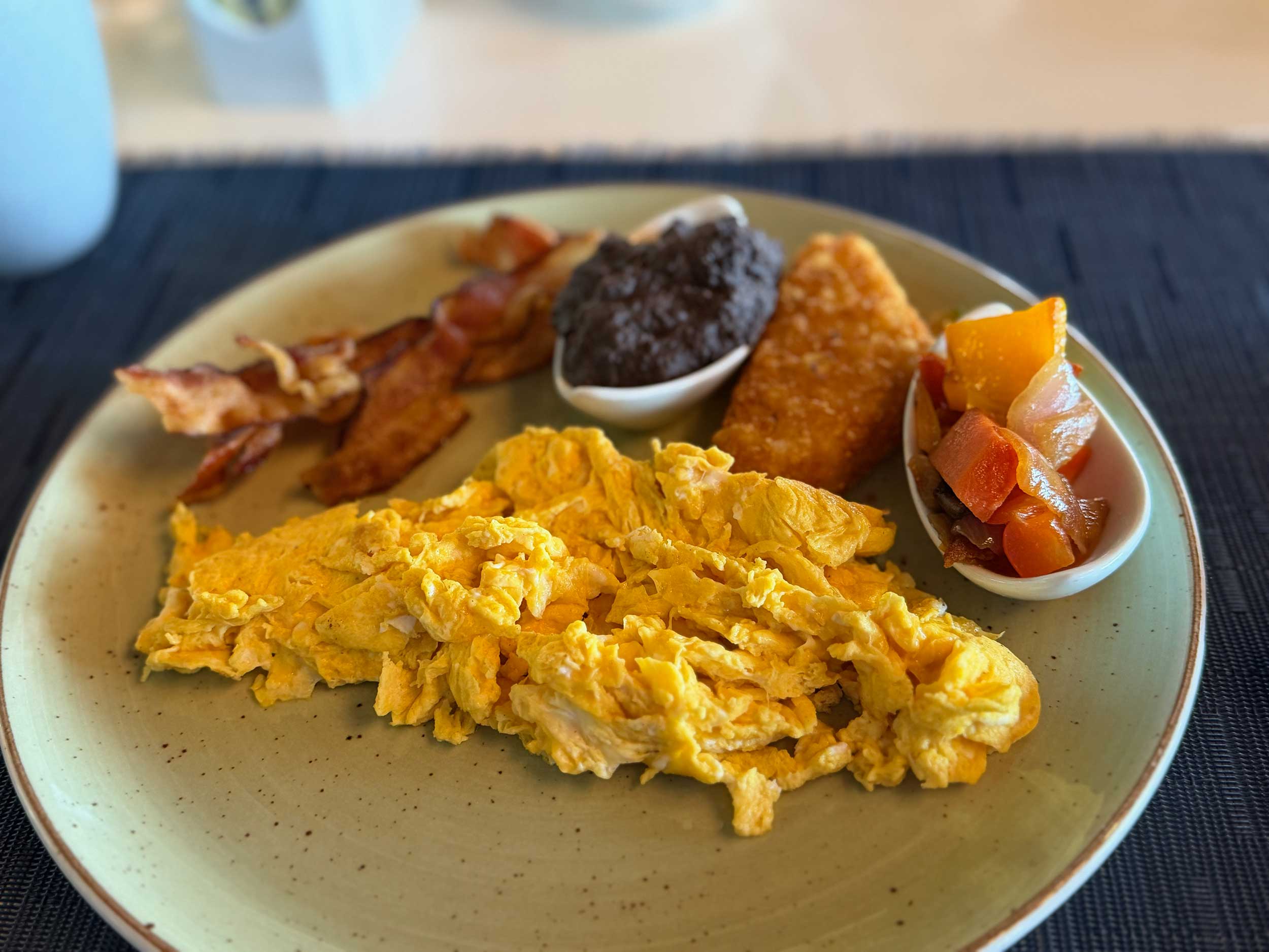 Breakfast with eggs, bacon and hash browns.