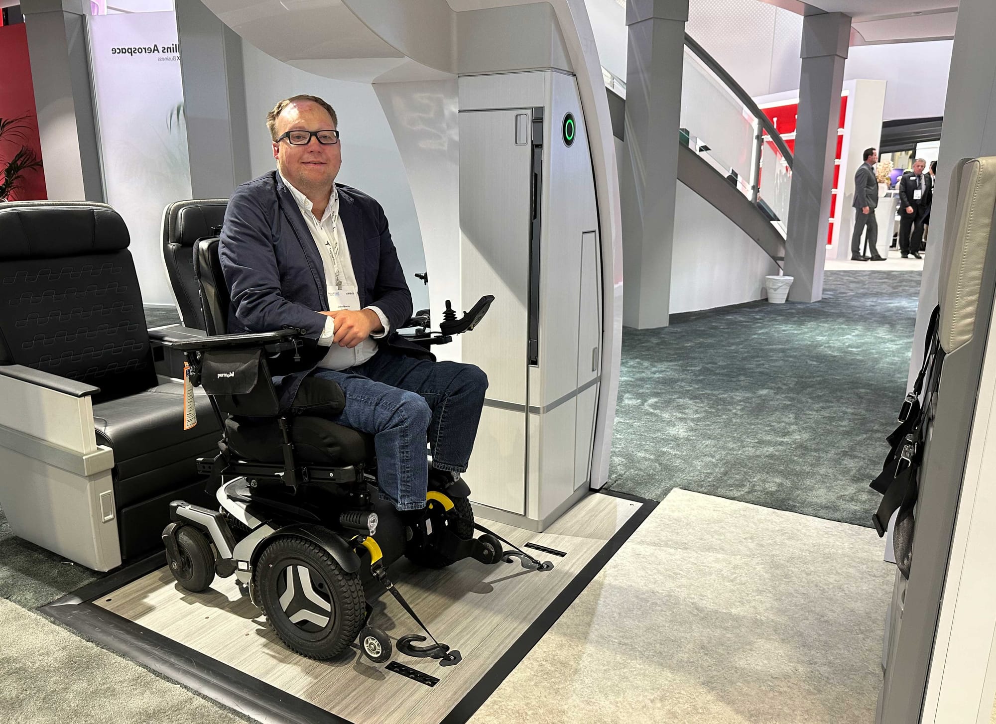 John's power wheelchair attached to a wheelchair securement space prototype.