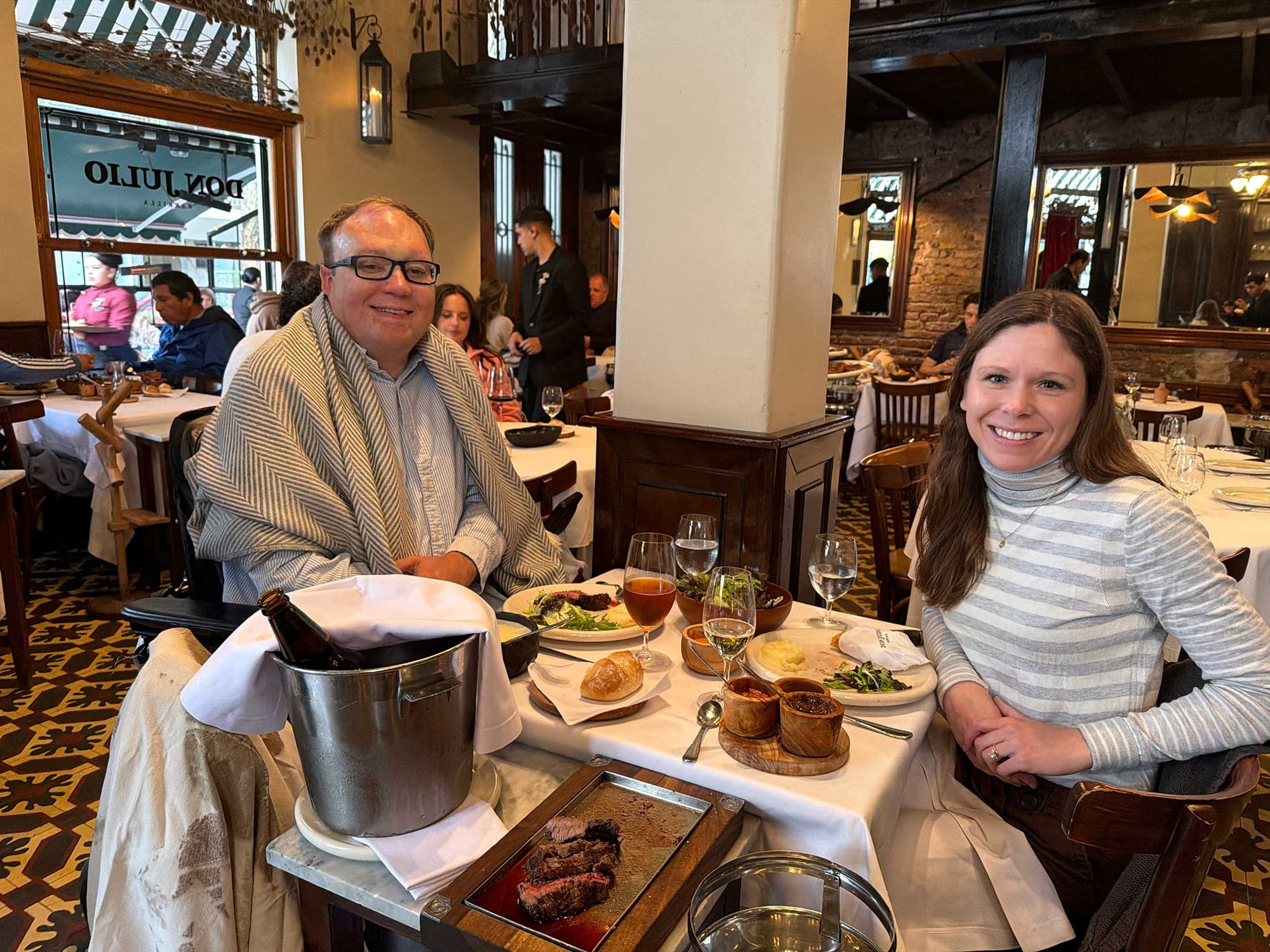 John and Stevie seated at a table inside restaurant.