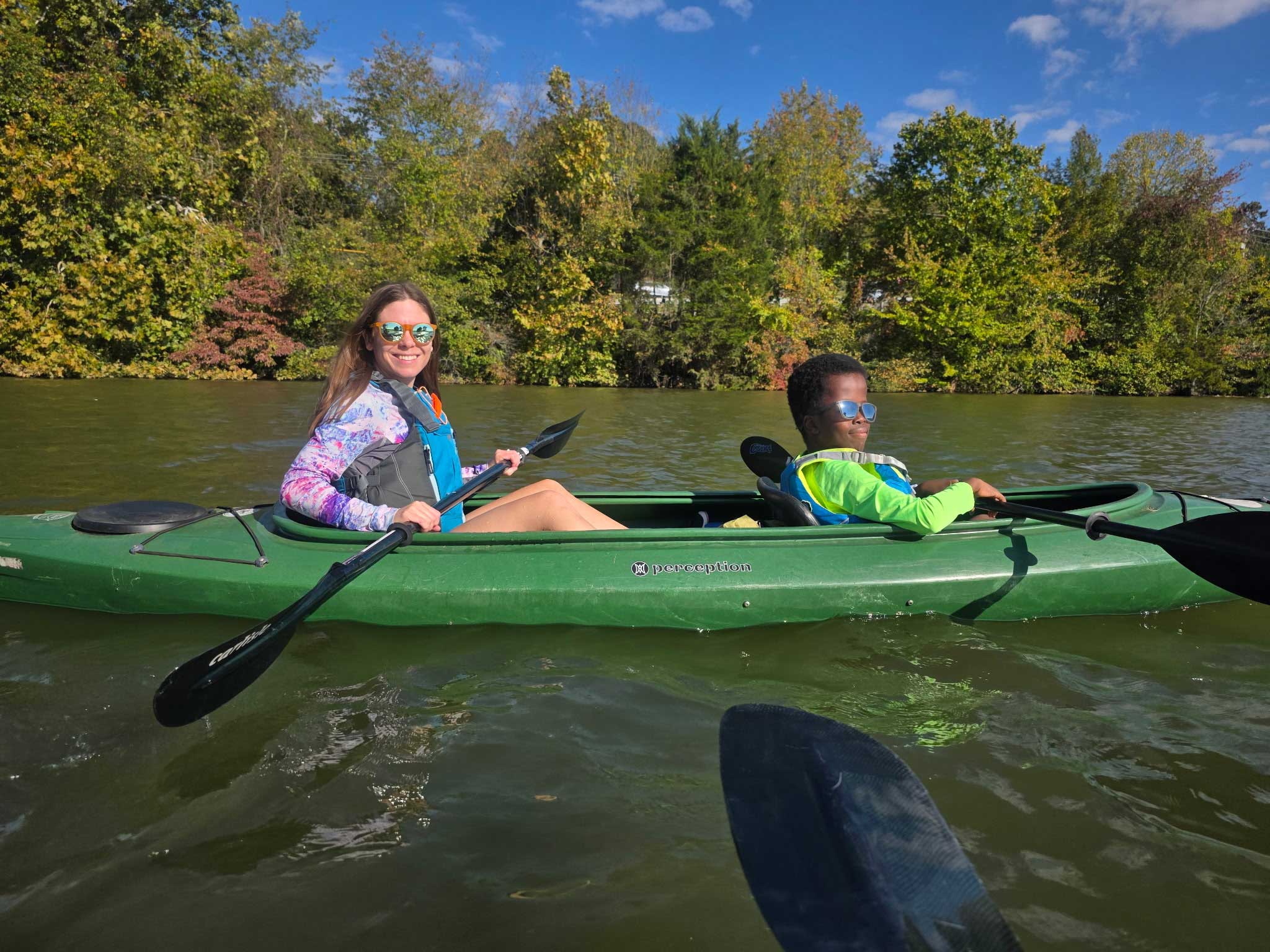 Stevie and Robert in a green kayak.
