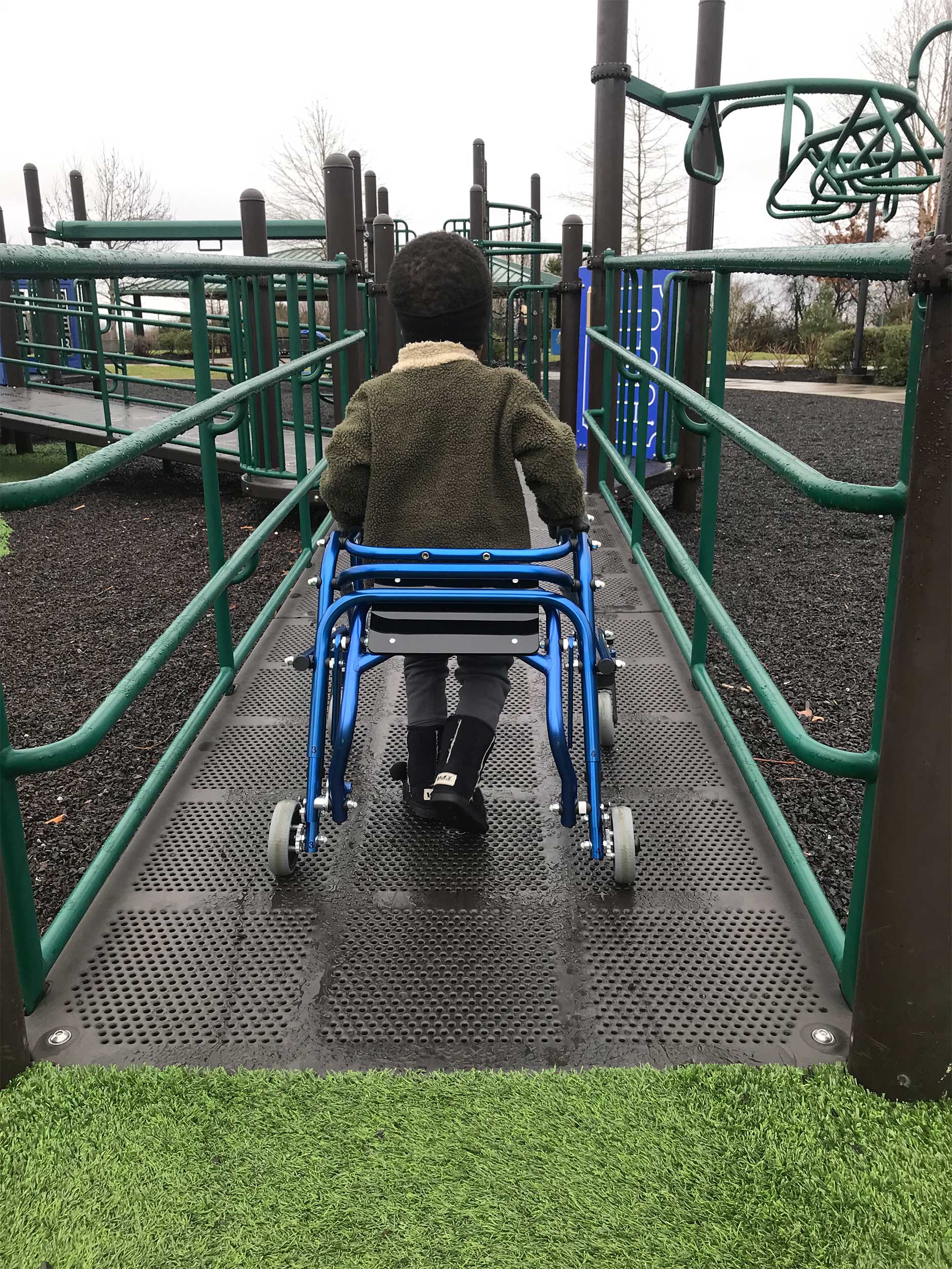 A young Robert using his walker on a playground.