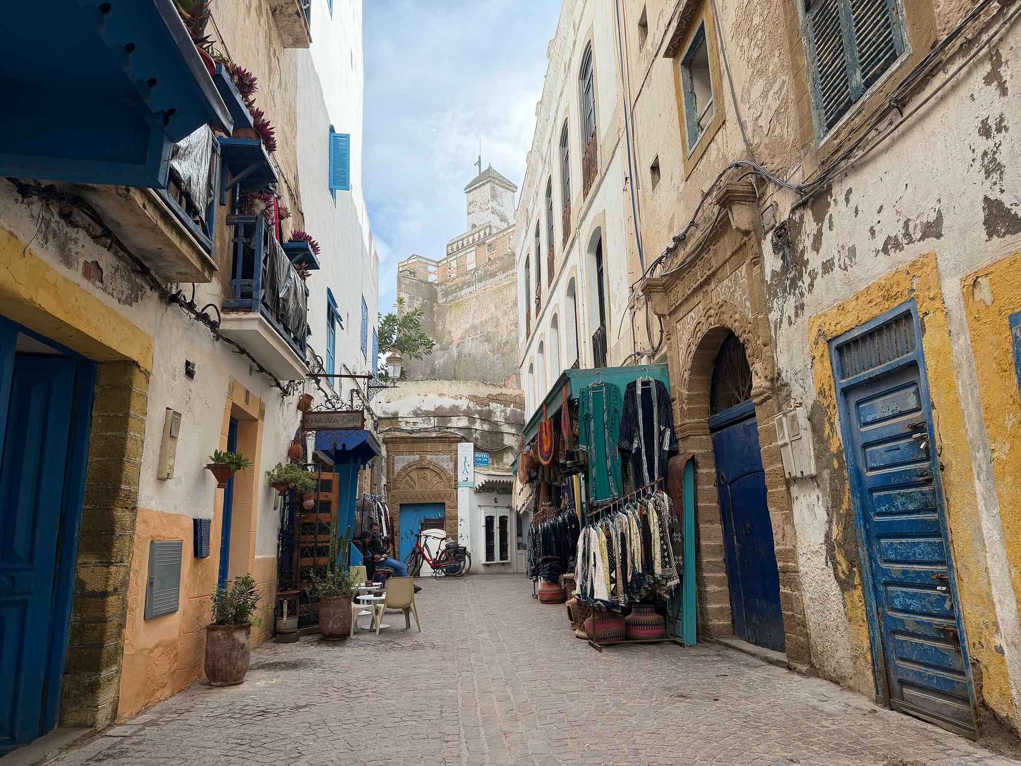 Old narrow street in town center, with castle-like tower overhead.
