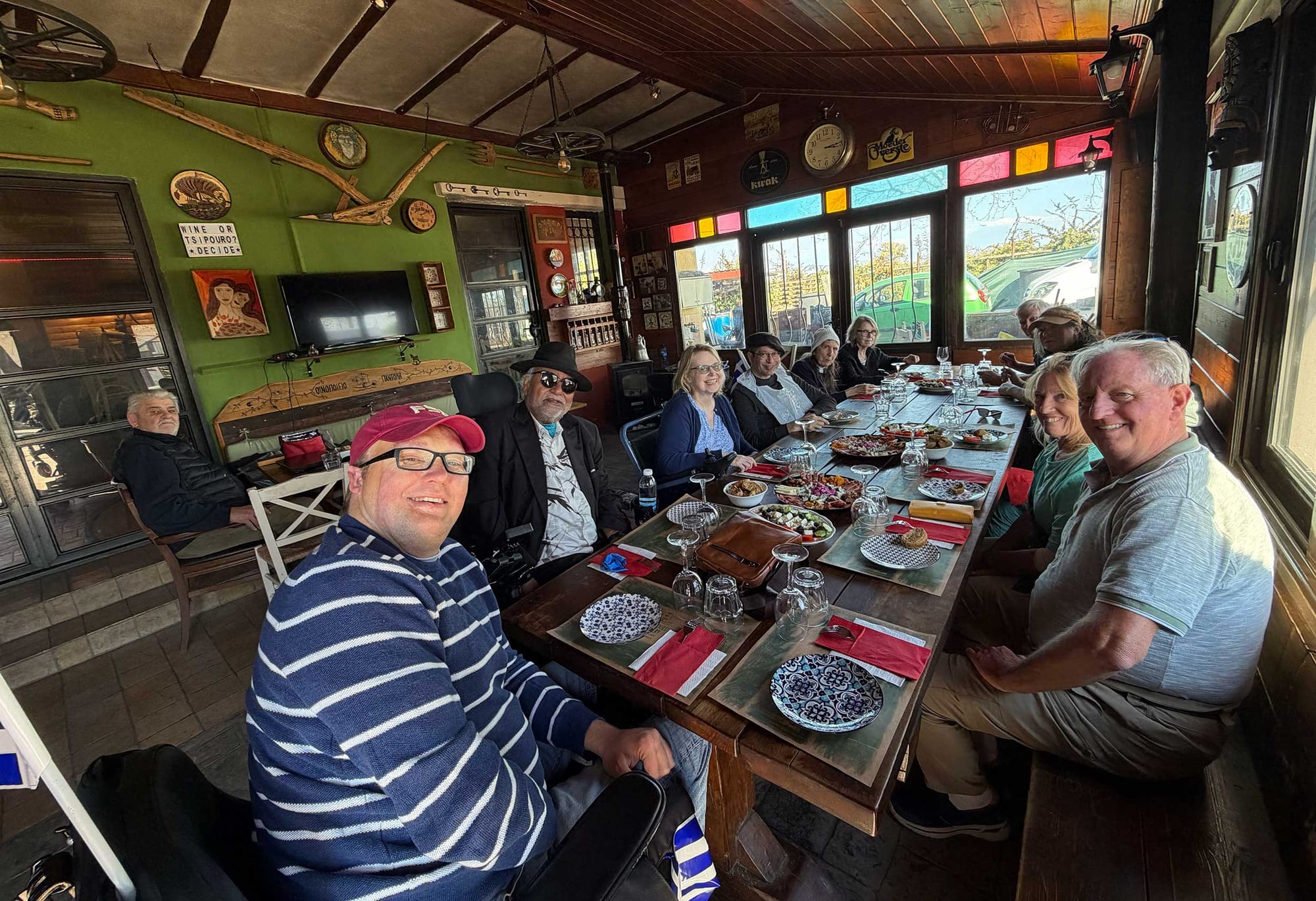 John pictured with a group of travelers inside a winery in Greece.