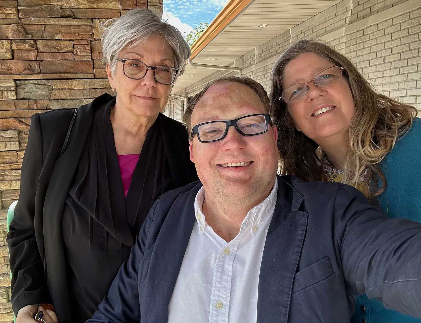 John taking a selfie with two women.