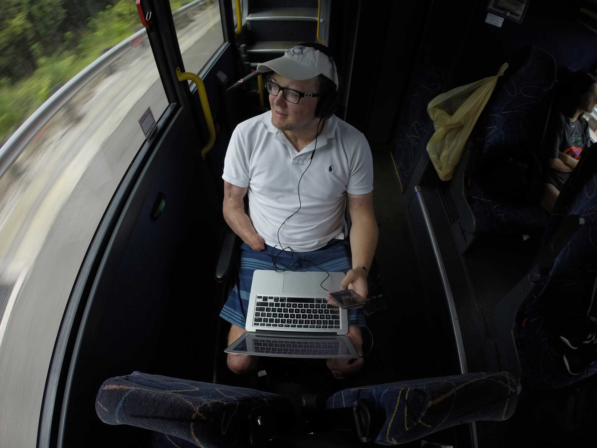 Overhead view of John seated in his wheelchair on a bus.
