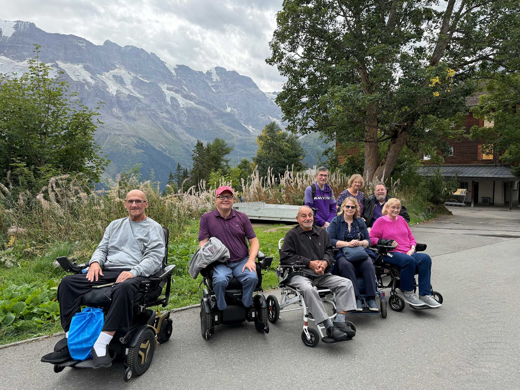 Wheelchair users in front of mountains in Switzerland.