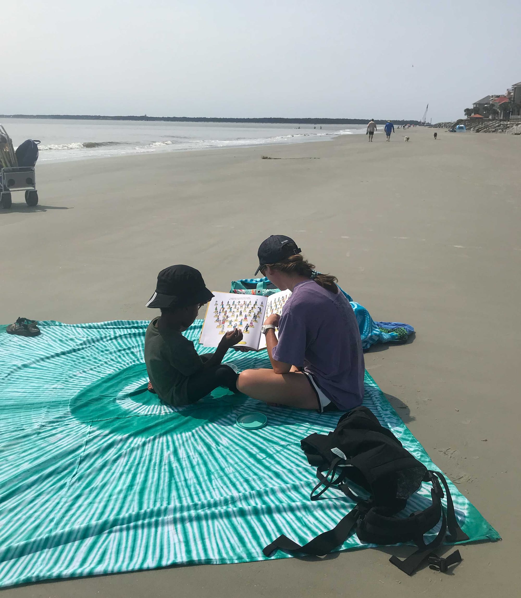 Stevie and Robert reading a picture book at the beach.