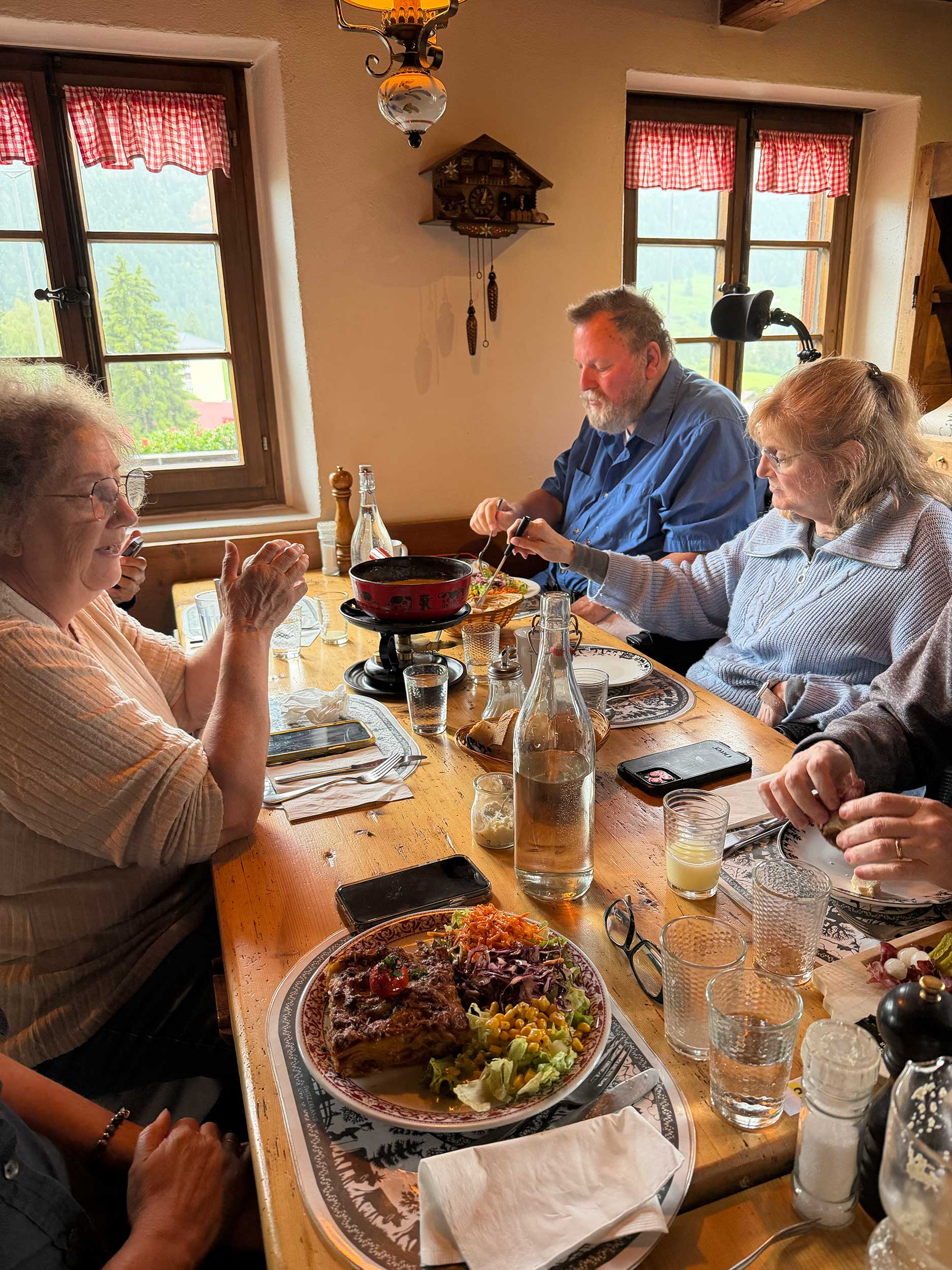 Group of travelers around a table eating fondue and other foods.