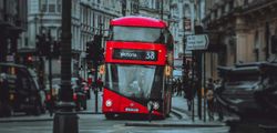Double decker London city bus driving on roadway.