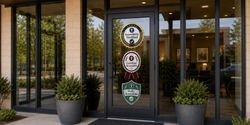 Business entrance door with accessibility certification badges.