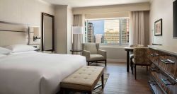 Hotel room with king size bed and wood floors.