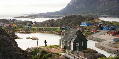 Houses spread across a rocky and hilly area in a Greenland village.