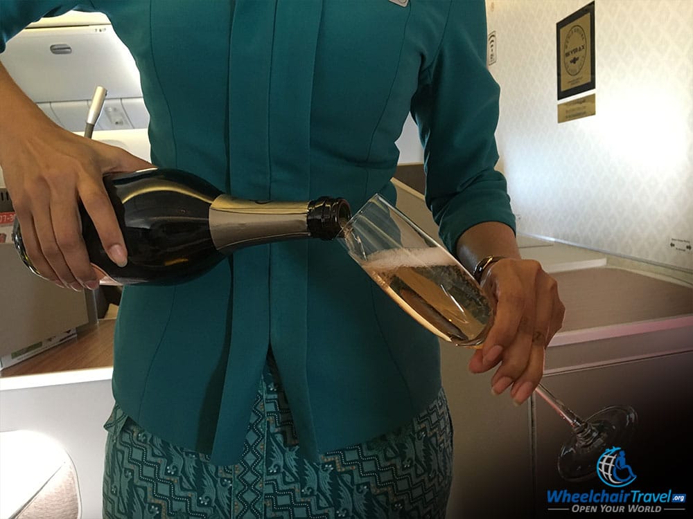 Garuda Indonesia Flight Attendant Poring Champagne in Business Class