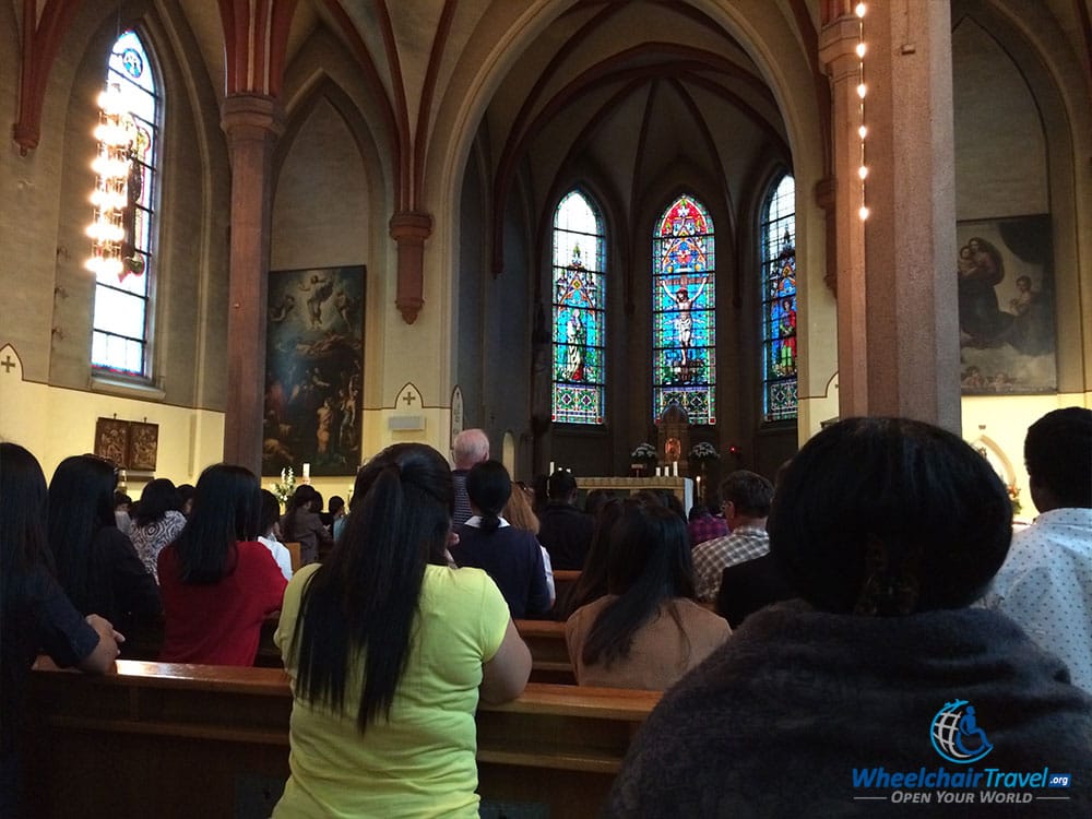 PHOTO DESCRIPTION: People sitting in prayer before Mass at St. Olav's Cathedral in Oslo, Norway.