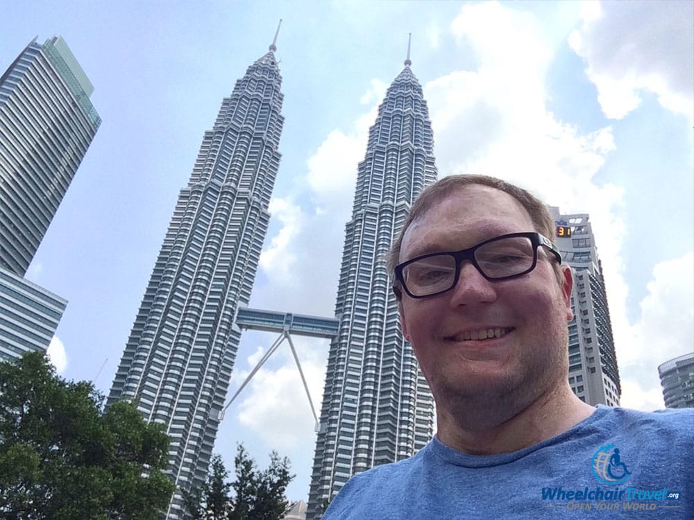 Wheelchair travel selfie with the Petronas Twin Towers in Kuala Lumpur, Malaysia.