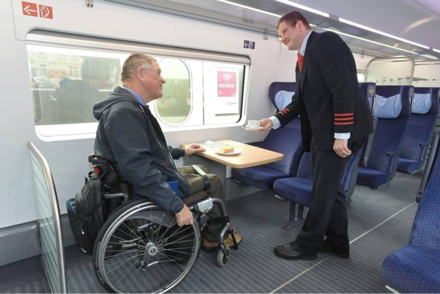 Wheelchair user seated at accessible space on train.
