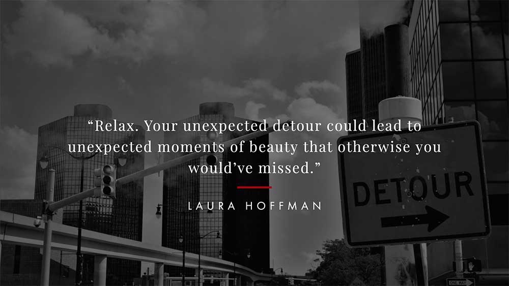 Detour sign posted on city street.