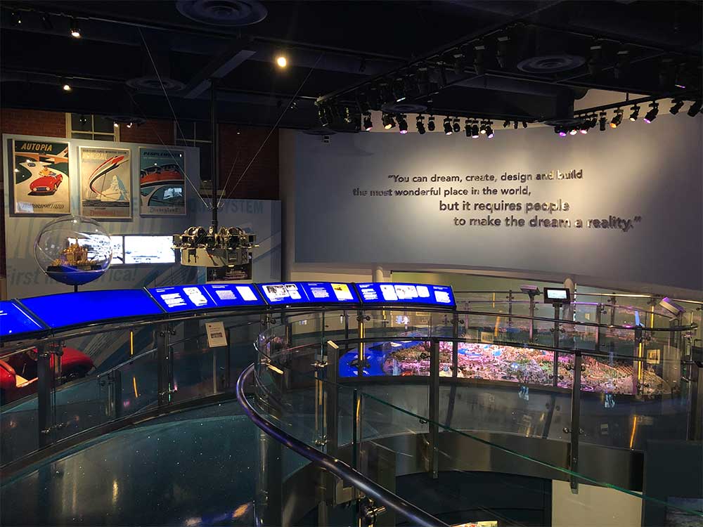 Ramp leading down to museum exhibit, with a quote posted on the wall in silver lettering.