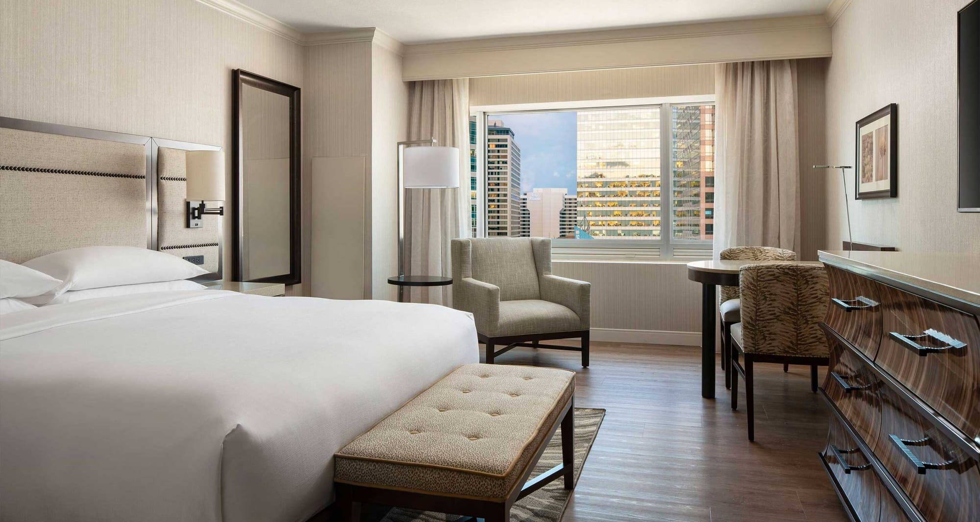 Hotel room with king size bed and wood floors.
