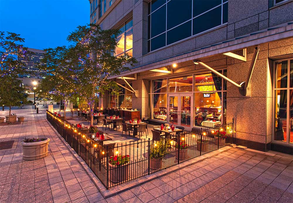 Tables on an outdoor patio enclosed with a small fence.