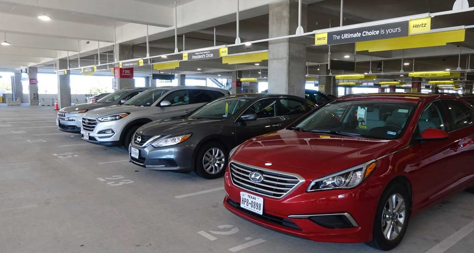 Rental cars lined up in a parking garage.