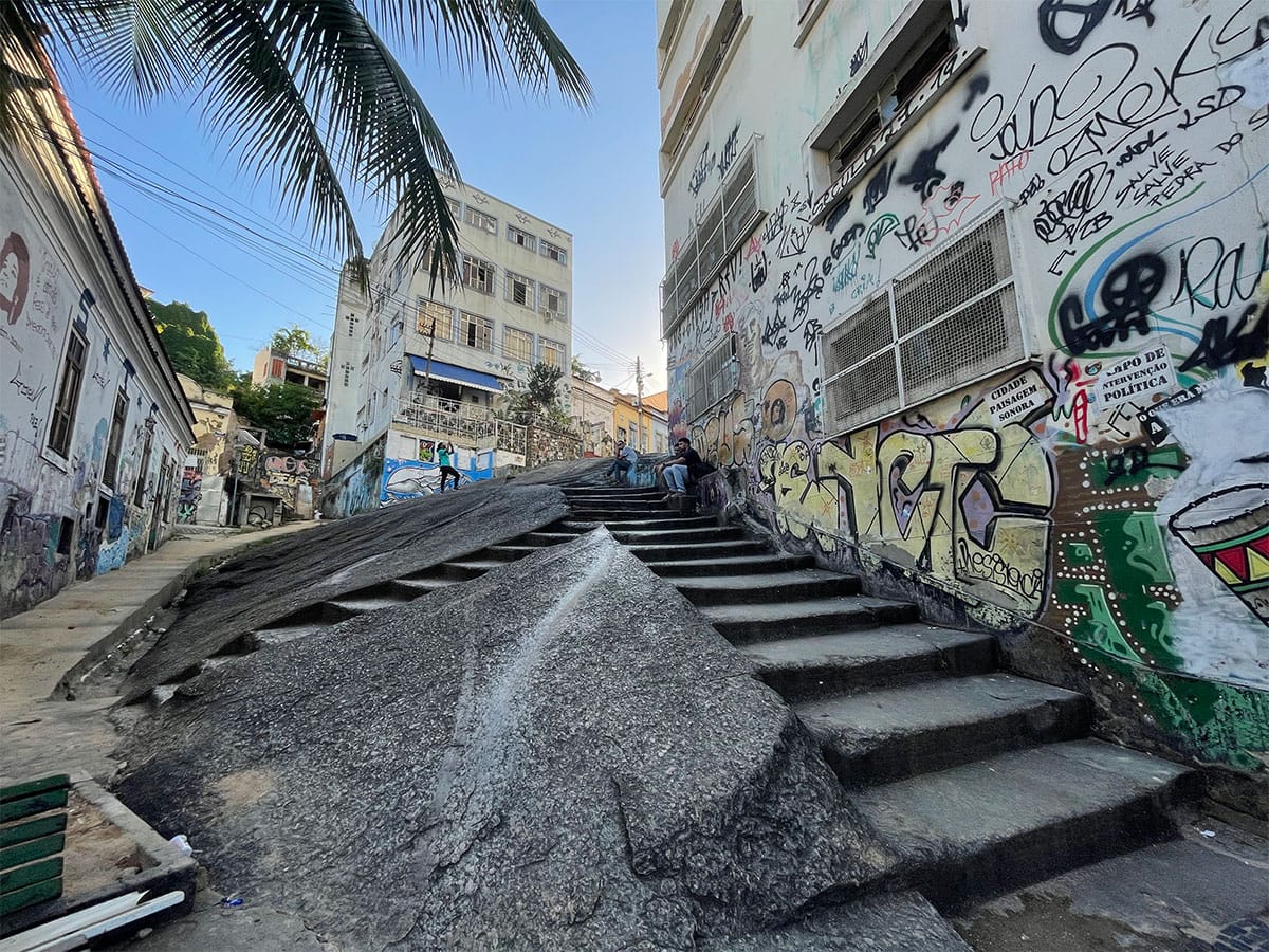 Stairs leading up the side of a hill in the center of an urban landscape.
