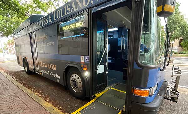 City bus with wheelchair ramp deployed onto sidewalk.