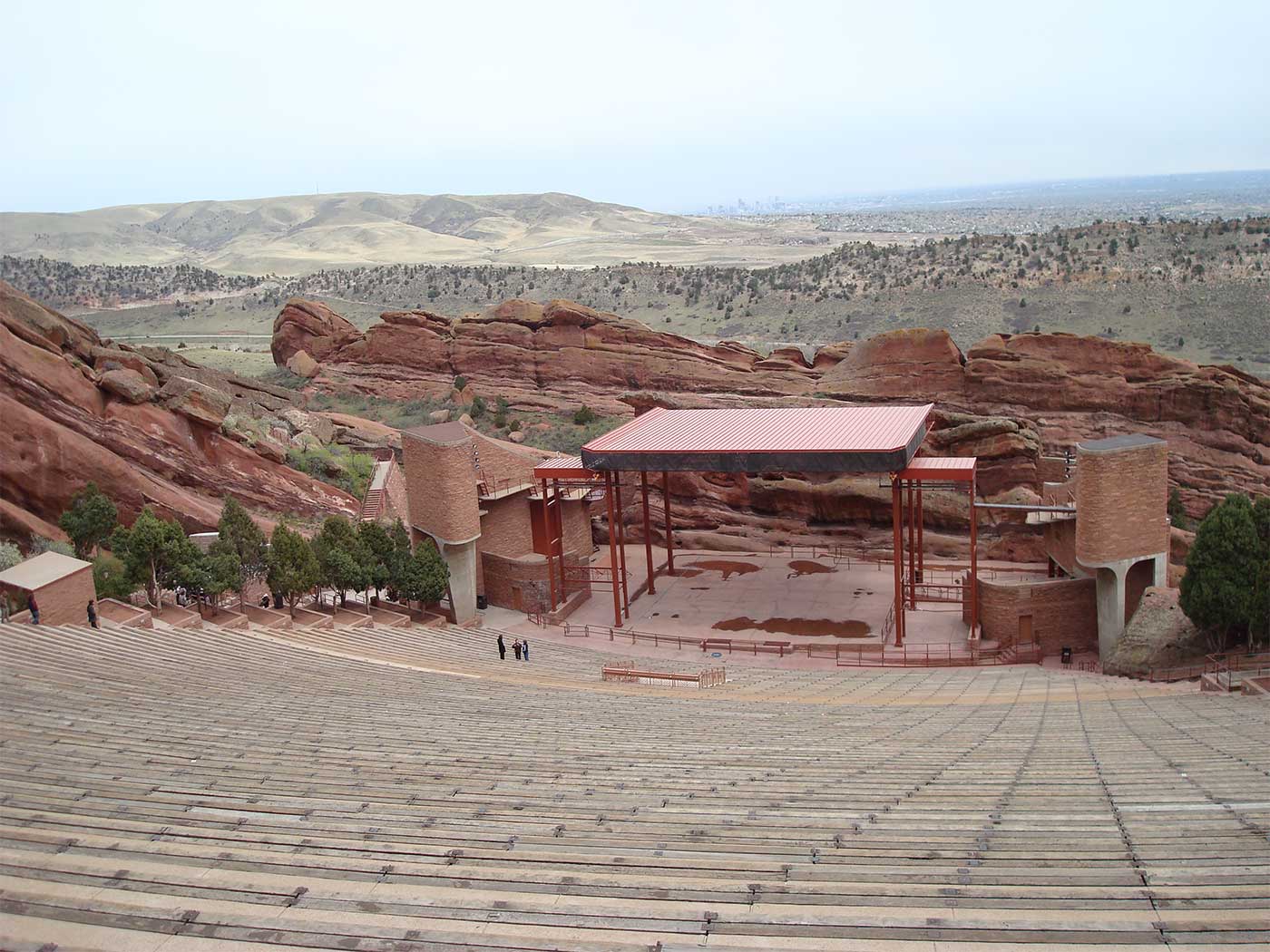 Many rows of seats leading down to a stage in a rocky canyon.