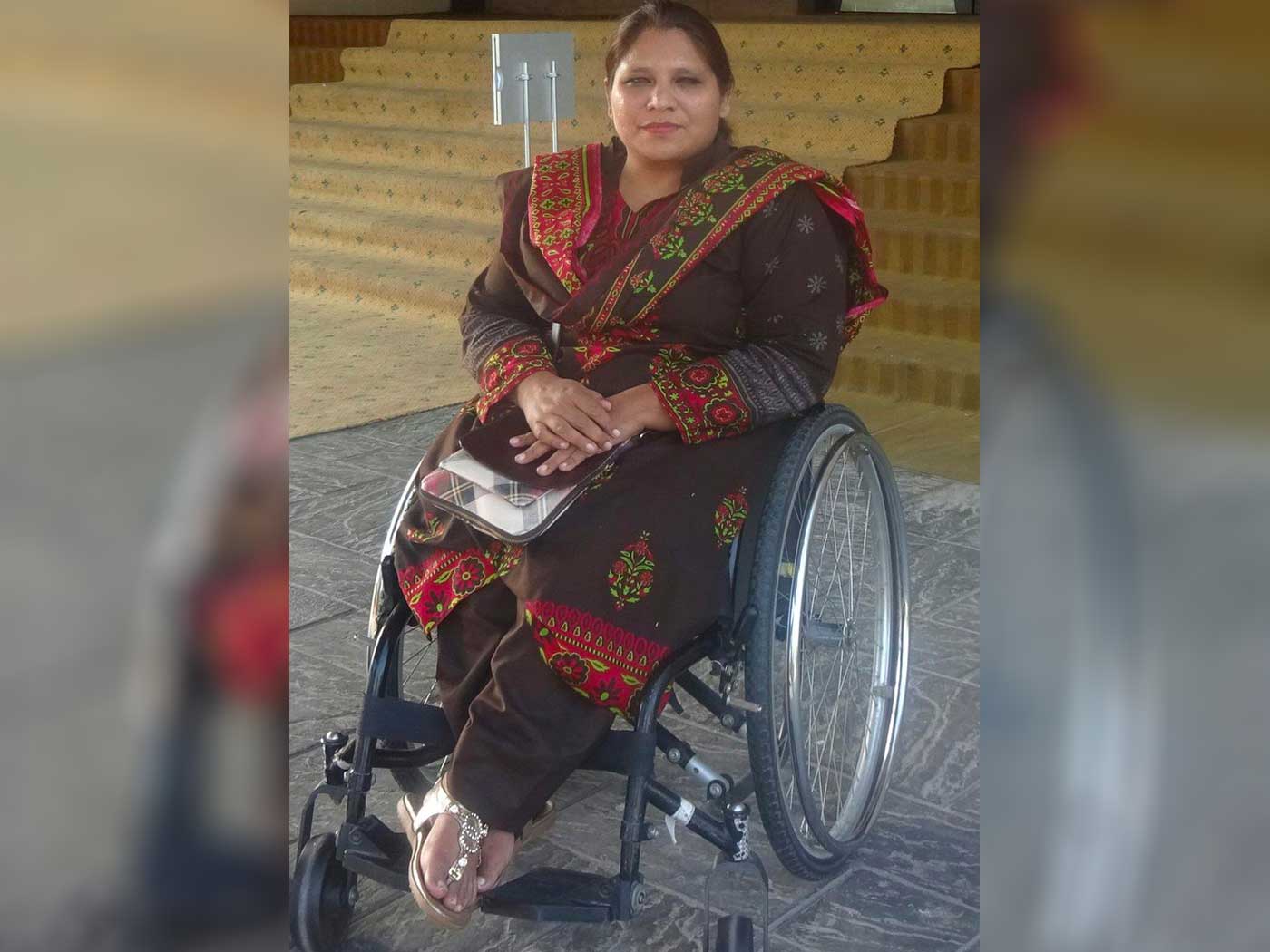 Pakistani woman sitting in wheelchair.