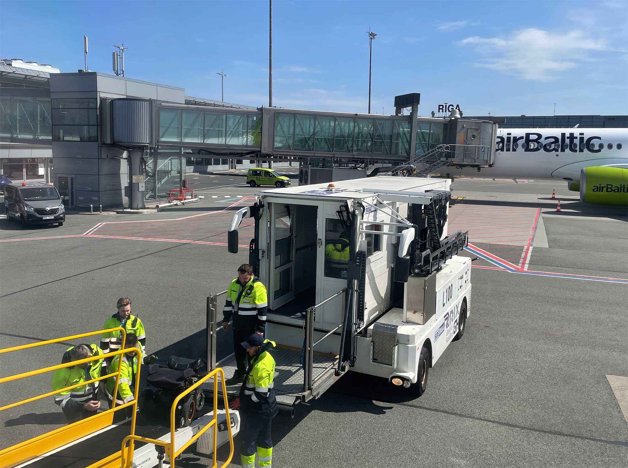 Wheelchair being pushed onto belt loader from Ambulift.