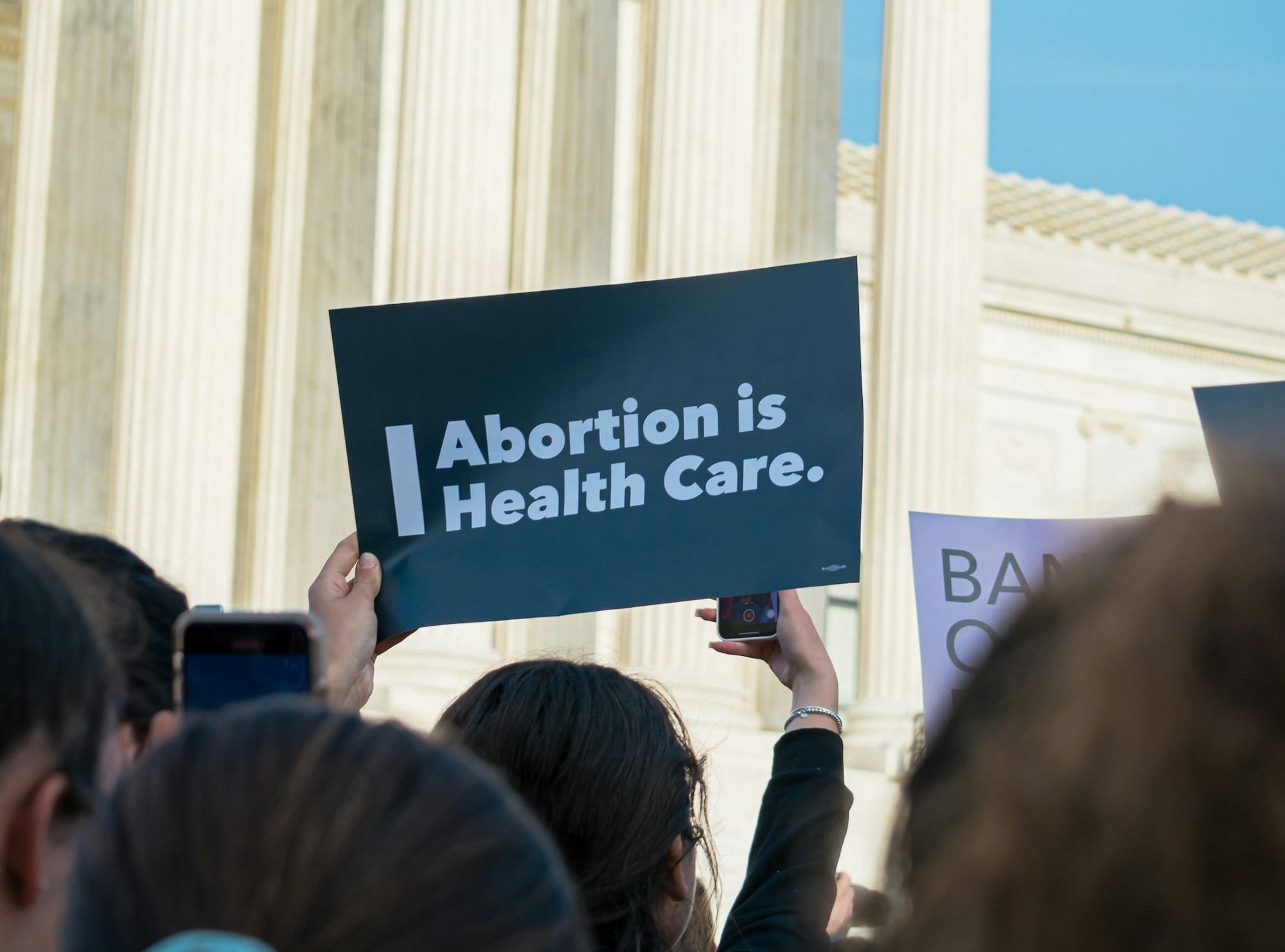 a group of people holding a sign in front of a building