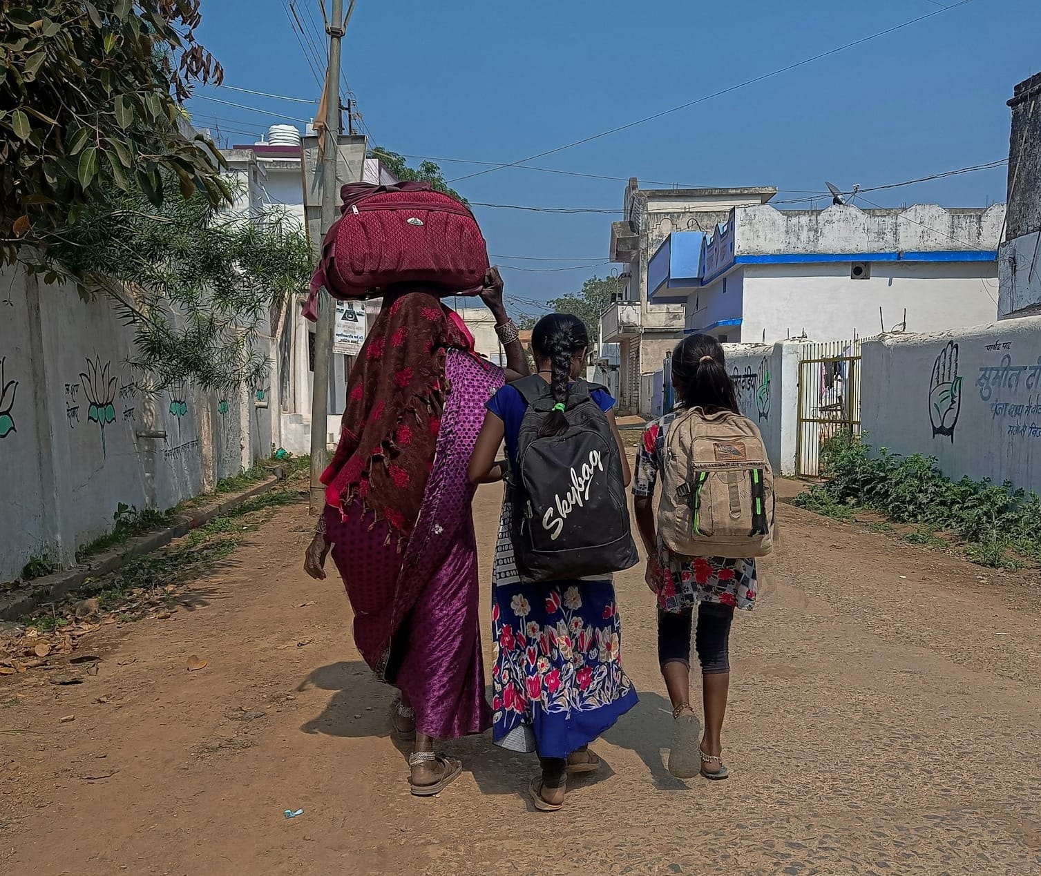 a group of women walking down a dirt road