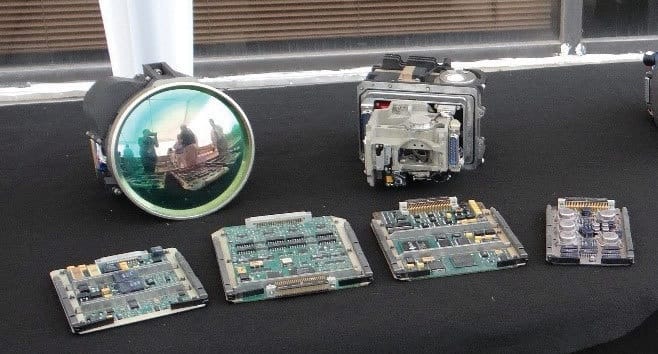 Third-generation FLIR optical hardware and four electronic circuit-board assemblies displayed on a table.