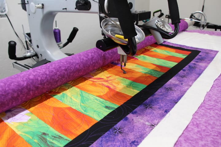 Gammill longarm quilting machine creating intricate edge-to-edge design patterns.