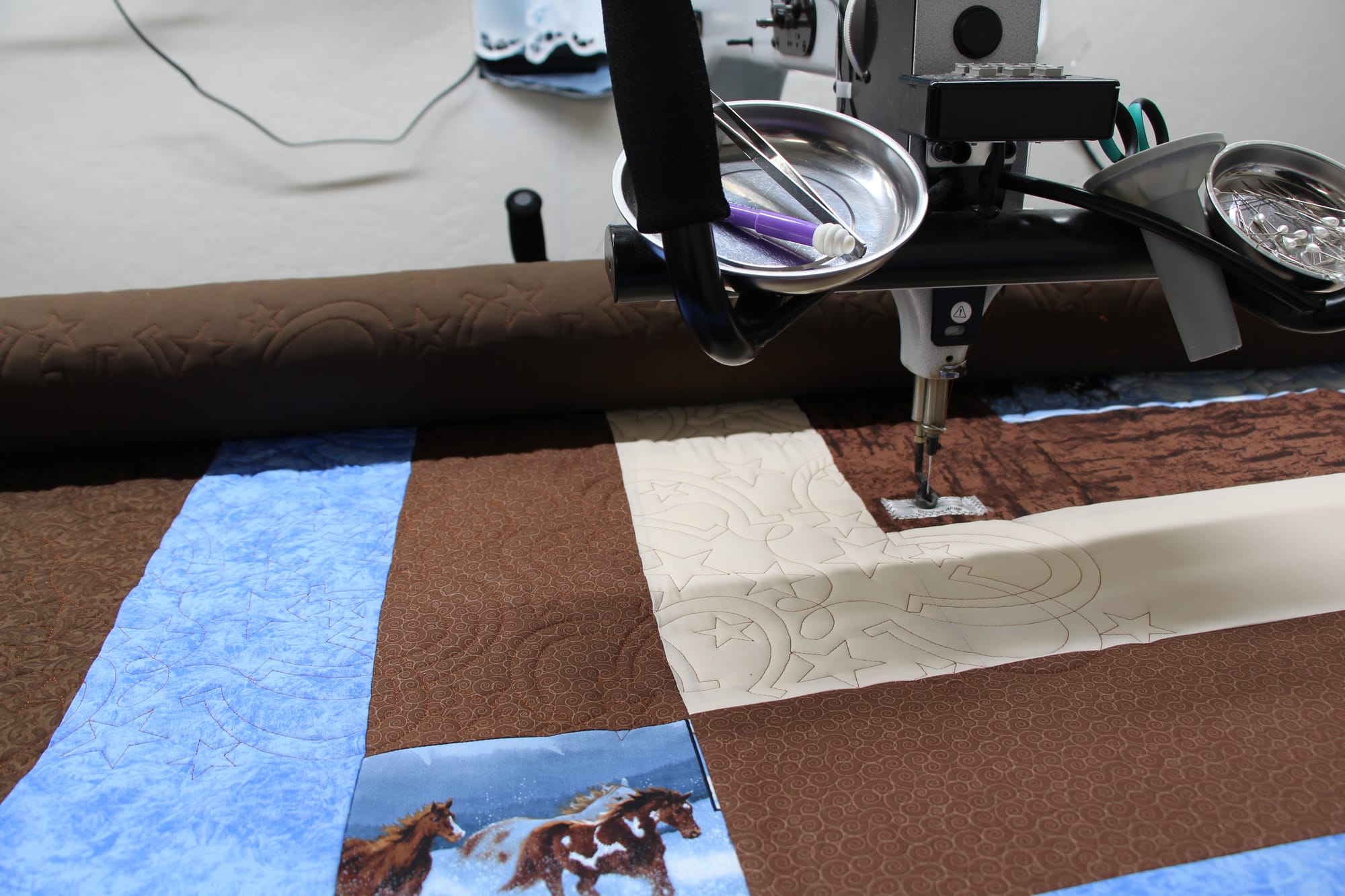 Machine photo showing close up of digital quilting design, showing the texture and pattern detail. 