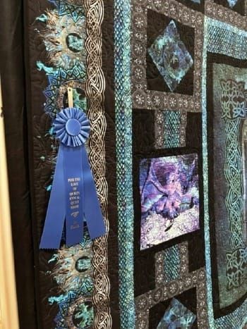 Sapphire War dragon quilt with blue first-place ribbon at the For the Love of Quilts Quilt Show.