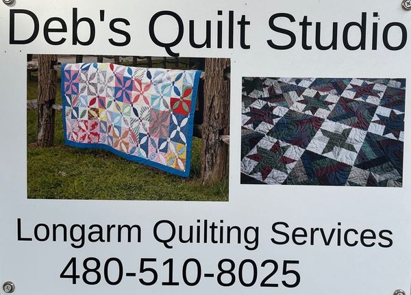 Deb’s Quilt Studio sign in Taylor, Arizona displaying handmade quilt examples and promoting professional longarm quilting services.