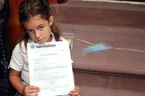 Natalie Shea with her warning letter and the alleged graffiti. Via The Brooklyn Paper