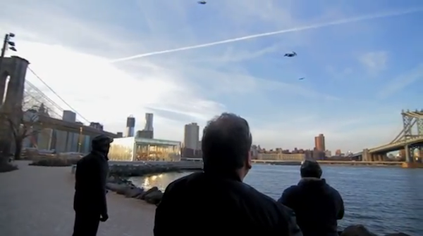 Visitors in DUMBO watch as RC planes shaped to look like people fly over the East River.