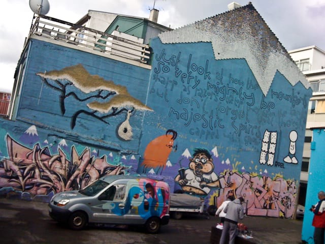 Giant mural, "Just look at how the mountains so very mighty be sharp as razors at the top they span the land + sea but don't forget that though majestic spires, capped in snow... From each and every grain of sand is how they grow"