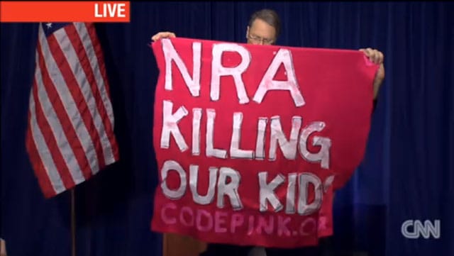 A sign held up by a Code Pink protester at the NRA's press conference on Friday, December 21 in Washington, DC. (via 