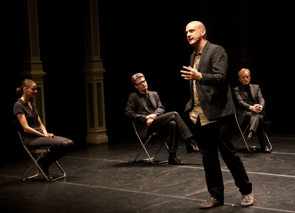 Image from an earlier iteration of Tea Tupajić and Petra Zanki’s “The Curators’ Piece (A Trial Against Art)” with Vallejo Gantner speaking to the audience, and seated (from left to right) Gundega Laiviņa, Florian Malzacher, and Per Ananiassen. (photo by Monica Santos Herberg)