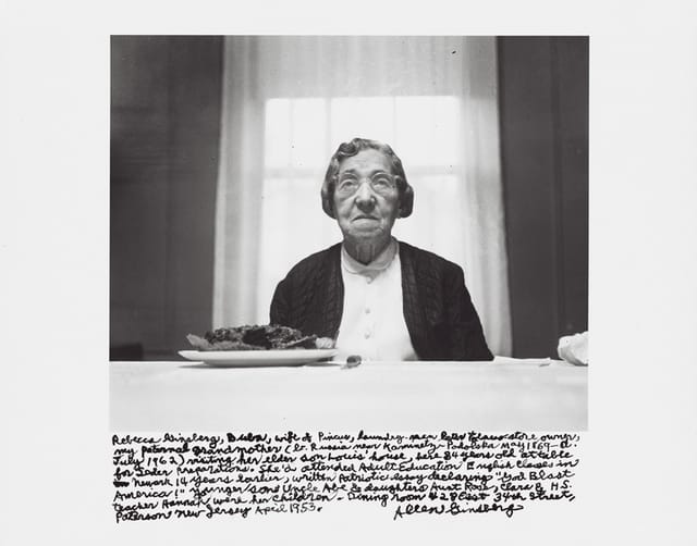 Allen Ginsberg, "Rebecca Ginsberg, Buba, wife of Pincus, laundry-man later tobacco-store owner, my paternal grandmother (b. Russia near Kaminetz-Podolska May 1869–d. July 1962) visiting her elder son Louis’ house, here 84 years old at table for Seder preparations. She’d attended Adult Education English classes in Newark 14 years earlier, written patriotic essay declaring “God Blast America!” Younger son Uncle Abe & daughters Aunt Rose, Clara & H.S. teacher Hannah were her children. Dining room 428 East 34th Street, Paterson New Jersey April 1953." (1953) Gelatin silver print, printed 1984–97 6 1/2 x 9 1/2 in. (16.5 x 24.2 cm)