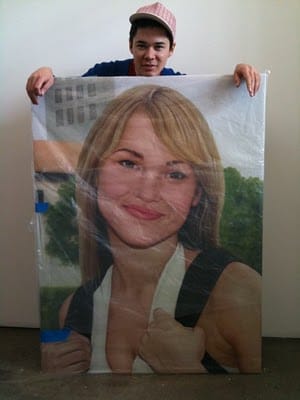 Parker Ito holding one of his commissioned art works.